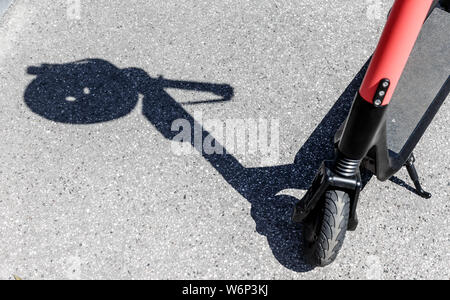 Hamburg, Deutschland. 23. Juli, 2019. Der Schatten eines Herlmes auf dem Griff eines elektrischen Pedal Roller kann an einer Vermietstation gesehen werden. Quelle: Markus Scholz/dpa/Alamy leben Nachrichten Stockfoto