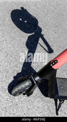 Hamburg, Deutschland. 23. Juli, 2019. Der Schatten eines Herlmes auf dem Griff eines elektrischen Pedal Roller kann an einer Vermietstation gesehen werden. Quelle: Markus Scholz/dpa/Alamy leben Nachrichten Stockfoto