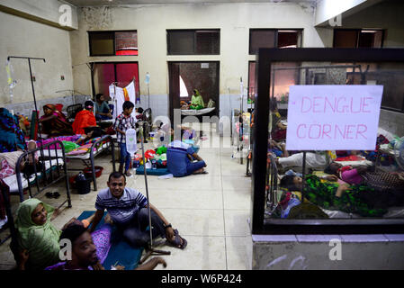 Dengue-fieber-Patienten auf dem Boden liegen und auf dem Bett außerhalb der Zulassung Abschnitt der Shaheed Suhrawardy Medical College Hospital in Dhaka, Banglade Stockfoto