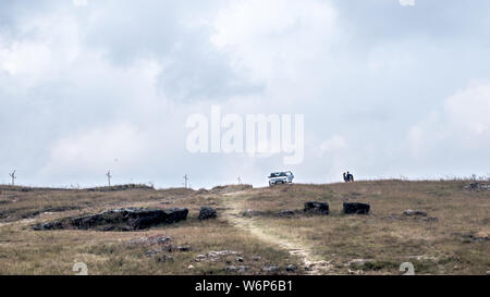 Reise Reise. Wiesen und blauer Himmel. Touristische Auto hält in weitem Abstand am frühen Morgen Self Drive Holiday, genießen Sie den atemberaubenden Blick von oben. Winde bl Stockfoto