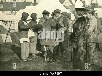 King George und Queen Mary besuchen Sie verwundeten Soldaten, Erster Weltkrieg, 1915, (c 1920). "Verwundeten Helden von Vorne: Ihre Majestäten einen der indischen Krankenhaus Lager' besuchen. Der britische König und die Königin im Gespräch mit indischen Soldaten ein Lazarett. Von "Die Große Welt Krieg - eine Geschichte" Band III, herausgegeben von Frank eine Mumby. [Das Gresham Publishing Company Ltd., London, c 1920] Stockfoto