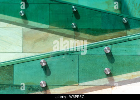 Die Details der modernen Architektur. Treppen in Grün, Orange und Gelb, aus Stein, Glas und Metall. Stockfoto
