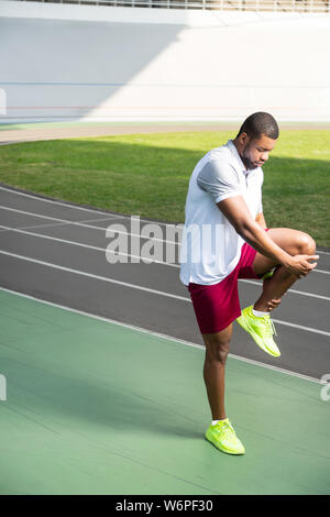 Junge afrikanische amerikanische männlichen Athleten zu tun Stretching Übungen Stockfoto