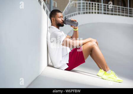 Ruhigen jungen männlichen Athleten im Stadion sitzen Stockfoto