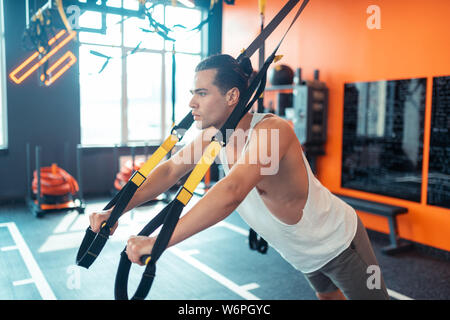 Gute Suche gut gebauten Mann mit einem TRX Training Stockfoto