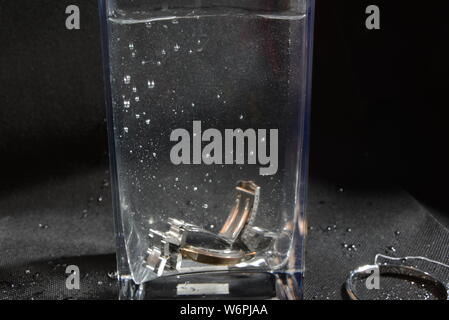 Professionelle foto Zubehör drop im Moment der herabhängend und Blasen im Wasser zu Wasser Stockfoto