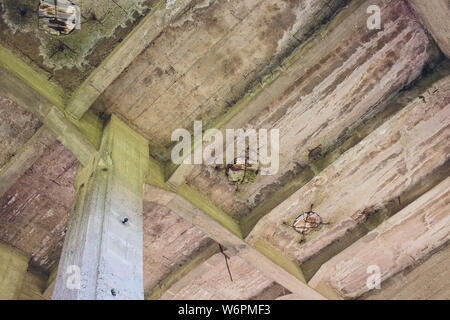 Die zerstörte große Gebäude aus Beton in einer nebligen Dunst. Die Überreste der Rahmen des grauen Betonpfeilern und Ablagerungen von der Gebäudestruktur. Hintergrund. Stockfoto