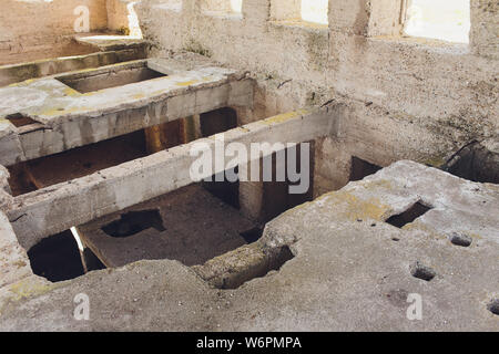 Die zerstörte große Gebäude aus Beton in einer nebligen Dunst. Die Überreste der Rahmen des grauen Betonpfeilern und Ablagerungen von der Gebäudestruktur. Hintergrund. Stockfoto