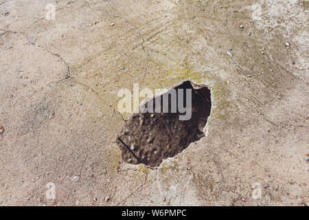 Risse Löcher auf der Betonwand durch Bohren, die Rohre Rohr in das Haus zu setzen. Stockfoto