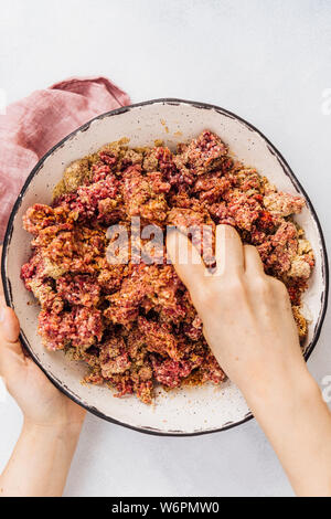 Die Kombination der köfte Zutaten mit Händen in eine keramische Schüssel Stockfoto