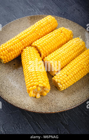 Lecker gekochte Maiskolben mit Butter und Salz auf Platte Stockfoto