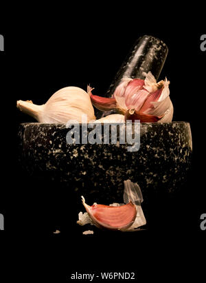 Einfach still life Shot von Knoblauch Zwiebeln in einem Mörser. Stockfoto