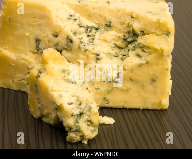 Zerbröckelnde Blauschimmelkäse auf einem Fliesen- Tabelle. Stockfoto