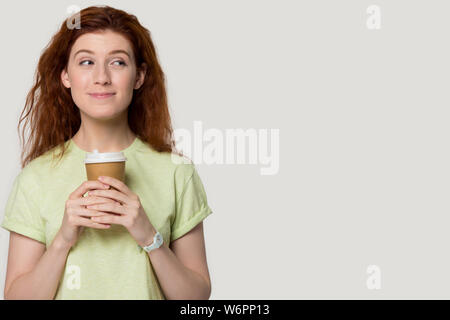 Cutie Mädchen stellen über grauen Studiohintergrund holding Kaffeetasse Stockfoto