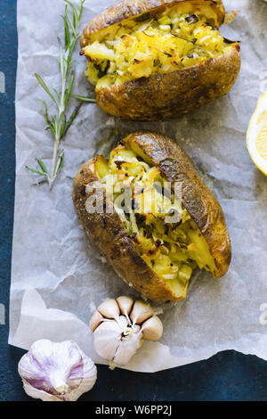 Doppelt gebackene Kartoffeln mit Frühlingszwiebeln, Knoblauch und Olivenöl mit grünem Pesto serviert. Stockfoto