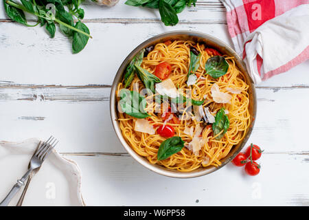 Pasta mit Auberginen, Tomaten und frischem Basilikum, serviert mit Parmesan Stockfoto