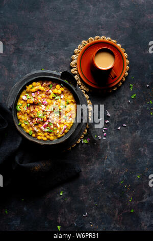 Indische Linsensuppe vegan Curry mit gehackten Zwiebeln, grüner Chili, Koriander, frisch gemahlene Gewürze serviert und frisch Chai. Stockfoto