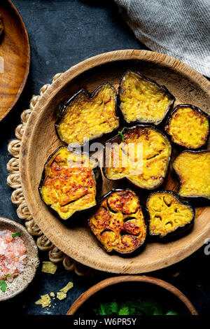 Bengali Khichdi - Linsen, Hirse Suppe - eine Glutenfreie vegane Mahlzeit serviert mit sautierten Aubergine, Mohn Krapfen, und papadum. Stockfoto