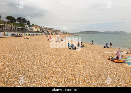 Lyme Regis Sandstrand im Frühjahr/Frühsommer an einem warmen Tag grau mit vielen Urlauber genießen das Meer und den Sand. Lyme Regis, England UK. (110) Stockfoto