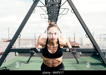 Fitness Frau tun Trizeps power Rack auf einer Terrasse dip Stockfoto