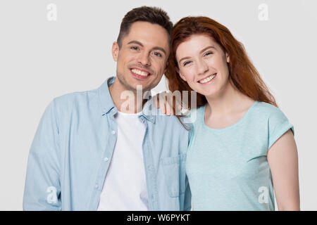 Kopf geschossen Studio Portrait glücklich attraktives Paar auf grauem Hintergrund Stockfoto