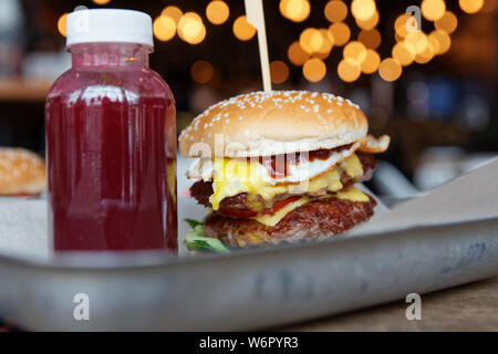 Burger und Berry Smoothie auf Metall Fach close-up, Fast Food Stockfoto