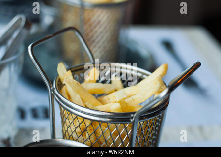 Frisch gebackene Pommes frites in einer metallischen Bratpfanne Warenkorb Stockfoto