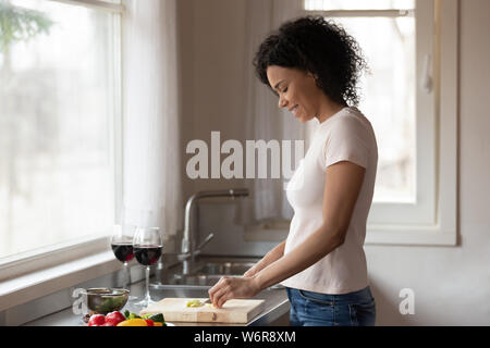 Gemischte Rasse Frau, die in der Nähe von arbeitsplatte vorbereiten Vegetarisches Abendessen Stockfoto