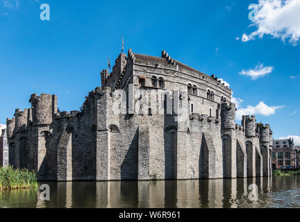 Gent, Flandern, Belgien - 21. Juni 2019: grauen Stein Burg und Stadtmauer von Gravensteen, historischen mittelalterlichen Burg der Stadt, hinter seiner Moad gegen Blu Stockfoto