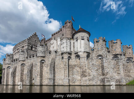 Gent, Flandern, Belgien - 21. Juni 2019: grauen Stein Burg und Stadtmauer von Gravensteen, historischen mittelalterlichen Burg der Stadt, hinter seiner Moad gegen Blu Stockfoto