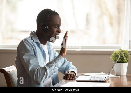 Afrikanische Kerl das Headset ab Lektion online Gruß Tutor Stockfoto