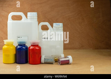 Das Mischen von Farbe epoxidharz in Schale aus Kunststoff zum Gießen Stabilisierung Holz und Pine Cone hybrid Stockfoto