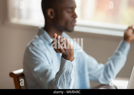 Serene afrikanischen Kerl drinnen entspannen Meditieren sitzen Stockfoto