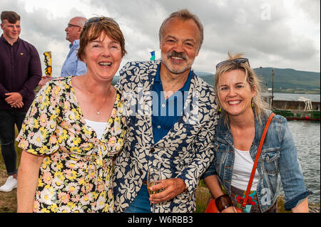 Ahakista, West Cork, Irland. August 2019. Im Rahmen des Ahakista August Festivals veranstaltet Graham Norton das jährliche Graham Norton Table Quiz. Besondere Gäste, Irland und Munster Rugby Spieler Fineen und Josh Wycherley nahmen ebenfalls am Festival Teil. Graham ist mit Noreen Daly, Kilcrohane und Teresa O'Brien, Tralee, abgebildet. Die Erlöse des Quiz gehen an die Ahakista Community Association. Quelle: AG News/Alamy Live News. Stockfoto