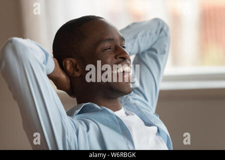 Afrikanische Kerl Arbeit vollenden Hände hinter dem Kopf fühlt sich zufrieden Stockfoto