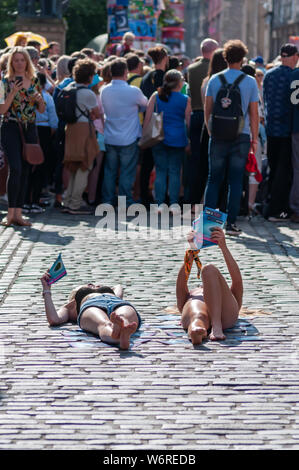 Edinburgh, Schottland, Großbritannien. 2. August 2019. Darsteller liegen auf dem Kopfsteinpflaster der Royal Mile Förderung der Show bekam einen Text auf der vergoldeten Ballon Veranstaltungsort während des Edinburgh Fringe Festival. Credit: Skully/Alamy leben Nachrichten Stockfoto