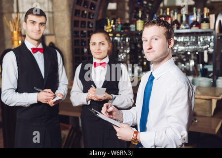 Manager's Briefing mit dem Kellner. Restaurant Manager und sein Personal Stockfoto