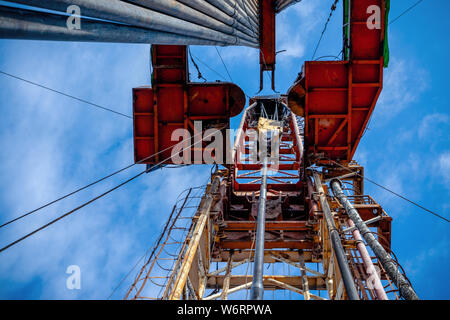 Bohrinsel Derrick im Ölfeld gegen den strahlend blauen Himmel. Bohranlage in Öl Feld für Bohrungen in den Untergrund, um Erdöl produziert. Petroleum I Stockfoto