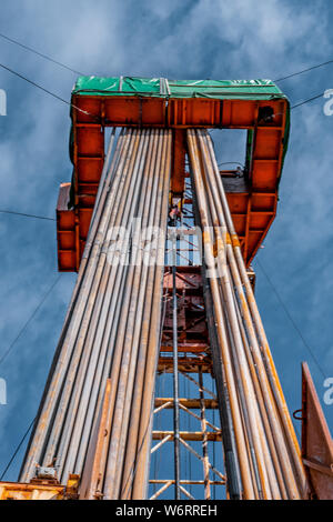 Bohrinsel Derrick im Ölfeld gegen den strahlend blauen Himmel. Bohranlage in Öl Feld für Bohrungen in den Untergrund, um Erdöl produziert. Petroleum I Stockfoto