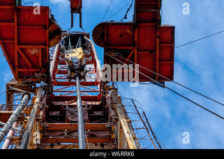 Bohrinsel Derrick im Ölfeld gegen den strahlend blauen Himmel. Bohranlage in Öl Feld für Bohrungen in den Untergrund, um Erdöl produziert. Petroleum I Stockfoto