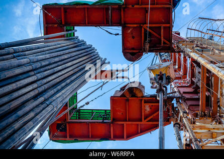 Bohrinsel Derrick im Ölfeld gegen den strahlend blauen Himmel. Bohranlage in Öl Feld für Bohrungen in den Untergrund, um Erdöl produziert. Petroleum I Stockfoto