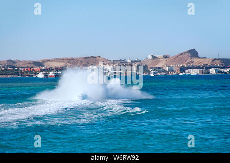 Schnelles Boot macht große Spritzer auf Meer Wasser und sanften Touristen am Roten Meer in Ägypten. Unterhaltung während der Ferien am Meer. Extreme Urlaub im seasi Stockfoto