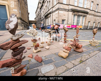 Edinburgh, Schottland, Vereinigtes Königreich, 2. August 2019. Sterling Gregory, ein Stein Balancer aus Amerika, Salden Steine auf einem Gehsteig während des Edinburgh Festival Fringe Stockfoto