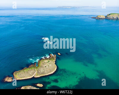 Lebendige, smaragdgrüne Wasser bei ballintoy Hafen entlang der Causeway Coast in der Grafschaft Antrim. Zerklüftete Küstenlandschaft von Nordirland. Stockfoto