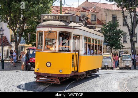 Die berühmten gelben Tram 28 vorbei vor der Kathedrale Santa Maria in Lissabon, Portugal Stockfoto
