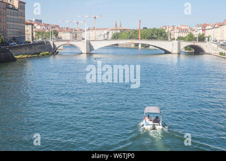 LYON, Frankreich - Juli 19, 2019: Boot nähert sich Pont Bonaparte Brücke der Saone Fluss in der Nähe des Quais de Saone Ufer und Fluss im Stadtzentrum Stockfoto