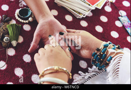 Wahrsagerin lesen fortune Linien auf der Hand Handlesen psychischen Messwerte und Hellsichtigkeit Hände Konzept mit Tarotkarten Wahrsagen Stockfoto