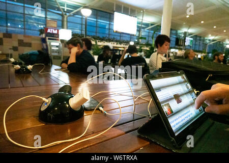 Reisende, die eine kostenlose Ladestation von Brisbane Flughafen International Terminal, Queensland, Queensland, Australien Stockfoto