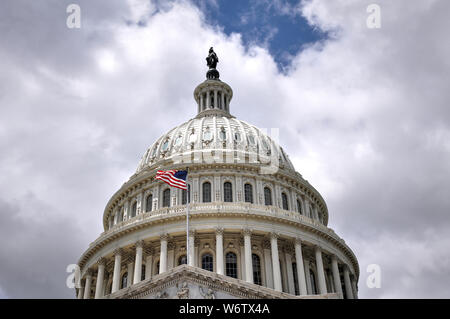 Nahaufnahme des United States Capitol Dome in Washington, D.C. Die amerikanische Flagge gegen helle, blaue Wolke Himmel. Stockfoto