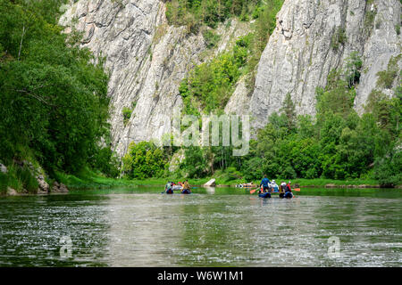 Eine Gruppe von Freunden in einem aufblasbaren Floß auf einem Fluss. Mountain River Wasser Landschaft Stockfoto